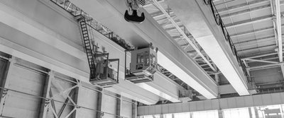 Deckenkonstruktion einer Halle mit Kränen und Haken.