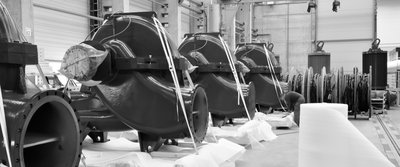 Große Pumpengehäuse in einer Produktionshalle, mit Schutzmaterialien und Verpackungsvorbereitung.