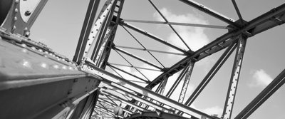 Metallkonstruktion einer Brücke aus genietetem Stahl unter freiem Himmel.